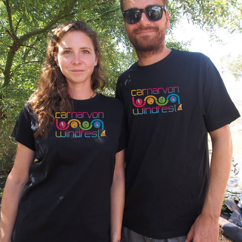Male and Female under a tree wearing black short sleeve t shirts with the Carnarvon Windfest Slalom graphic design Tee Shirt. 
