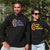 Male and female wearing black long sleeve t shirts with graphic design with NAIDOC Theme For Our Elders with footprints