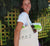 Female using a short Handle Shopper Style Calico Bag, natural colour.. The design is in black. The graphics are 4 outline images with words underneath and a plus sign in between. The images are of a bird, bee, flower and tree.