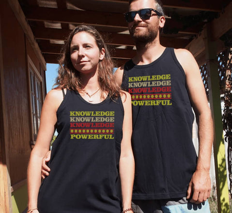Male and Female outside a house wearing Black Short Sleeve T Shirt. Graphic is stacked words in shades of yellow and red. The text reads Knowledge, repeated 3 times, and Powerful.