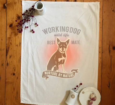 Flat Lay in a kitchen, natural Colour Tea Towel. Graphic of a dog with text reading Working Dog.  Wild Life.  Best Mate.  Nurture by Nature.