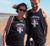 Male and female on a beach wearing black singlet tank T Shirts.  Design in blue and pink.  Surfboard with banner saying Wind Festival.  Text reads Carnarvon Western Australia.  West Coast. Surf Side. Indian Ocean. 6701. Chasing the wind.