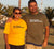 Female and Male wearing short sleeve t shirts.  She is wearing golden yellow with the design in black. He is wearing khaki with the design in white.  Graphic of two statements.  Think flexibly, Think alternatively.