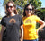 Two Females in a garden wearing Golden Yelllow or Black  Short Sleeve T Shirts.  Graphic is a rainbow with a leaf with the statement, cool, calm and collected.