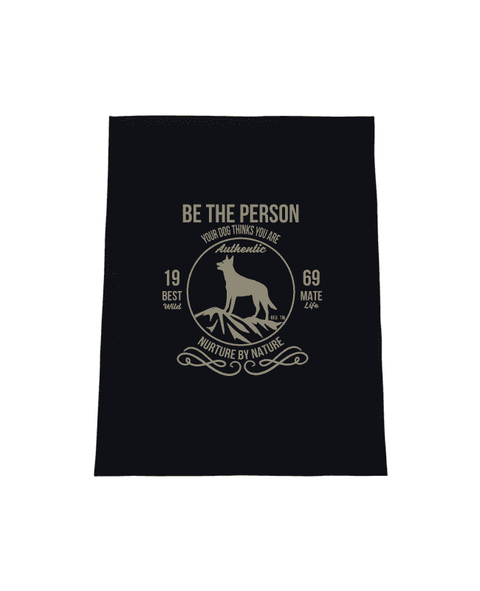 Black Tea Towel with design. The graphic is one colour.  There is a circle outline with a silhouette of a dog standing on a rocky outcrop.  Around the circle the text says - Be the person your dog thinks you are, Nurture by Nature.  On either side of the circle there is text that is split - it says 19-69, Best Mate, Wild Life