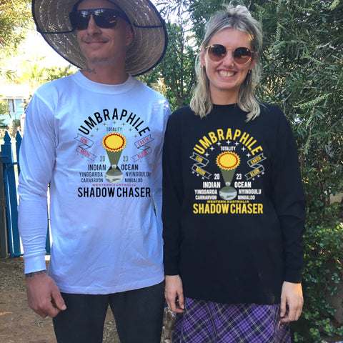 Male and Female wearing white or black long sleeve t shirts - the design is a Limited Edition Umbraphile Shadow Chasers  concept with the words- Sun Moon Earth Indian Ocean Solar Eclipse Totality Adventure