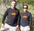 Male and Female wearing Long Sleeve Black T - shirt - with graphic - of australia map in traditional boundaries - in red.  Overtop of the map are the words Always Was Always Will Be, written in yellow. Malagana Country Highlighted