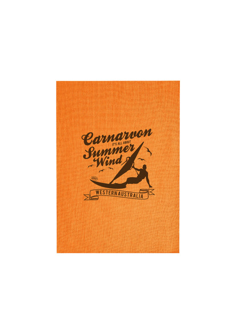 Orange Tea Towel.  Design in black.  Graphic is a silhouette of a kite surfer with the text Carnarvon Western Australia.  It's all About the Summer Wind.